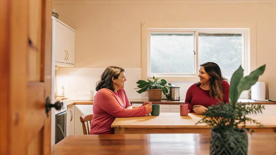 Two women chatting over coffee at a kitchen table